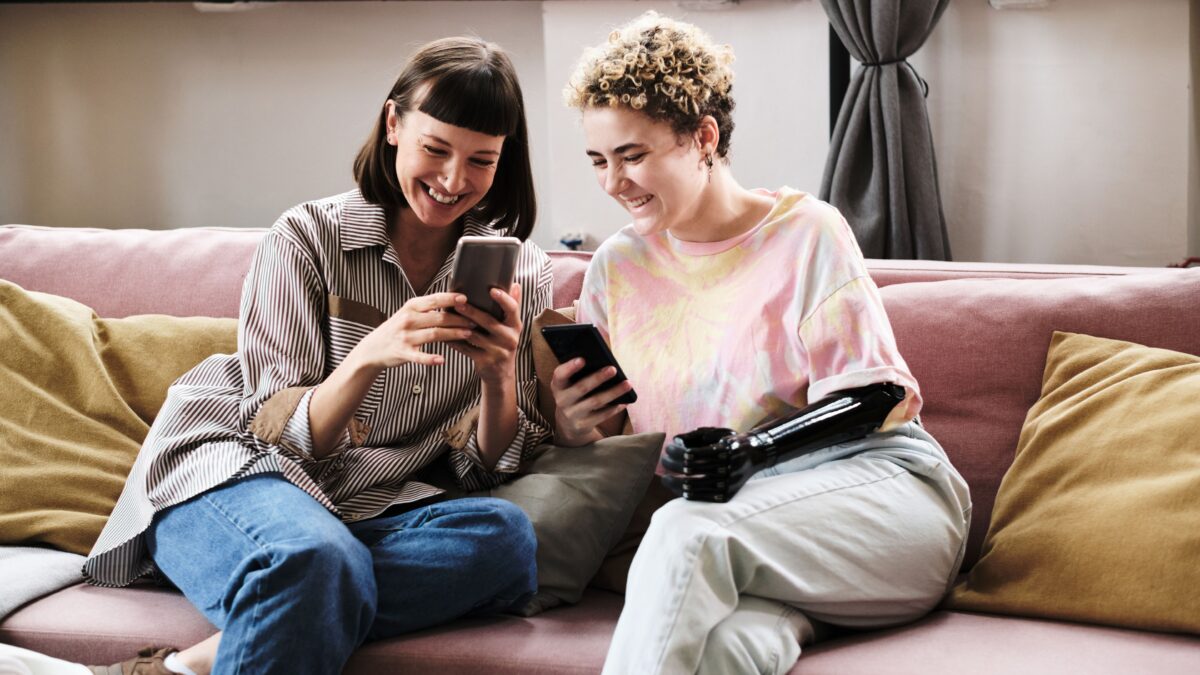 Two girlfriends using mobile phone