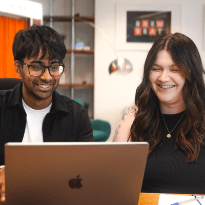 Designer, Tarren, and Senior Designer, Sarah, reviewing work on laptop