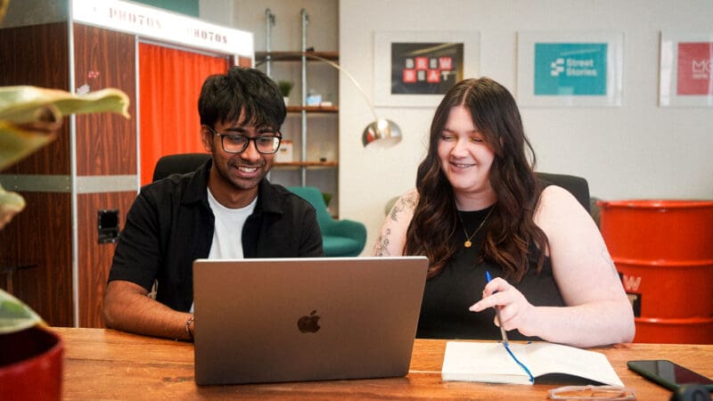 Designer, Tarren, and Senior Designer, Sarah, reviewing work on laptop