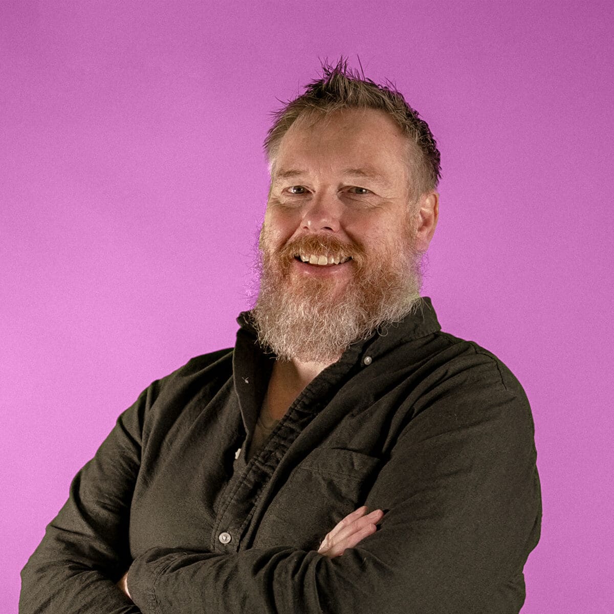 Headshot of Luke Harrison, Founder & Director, on pink background
