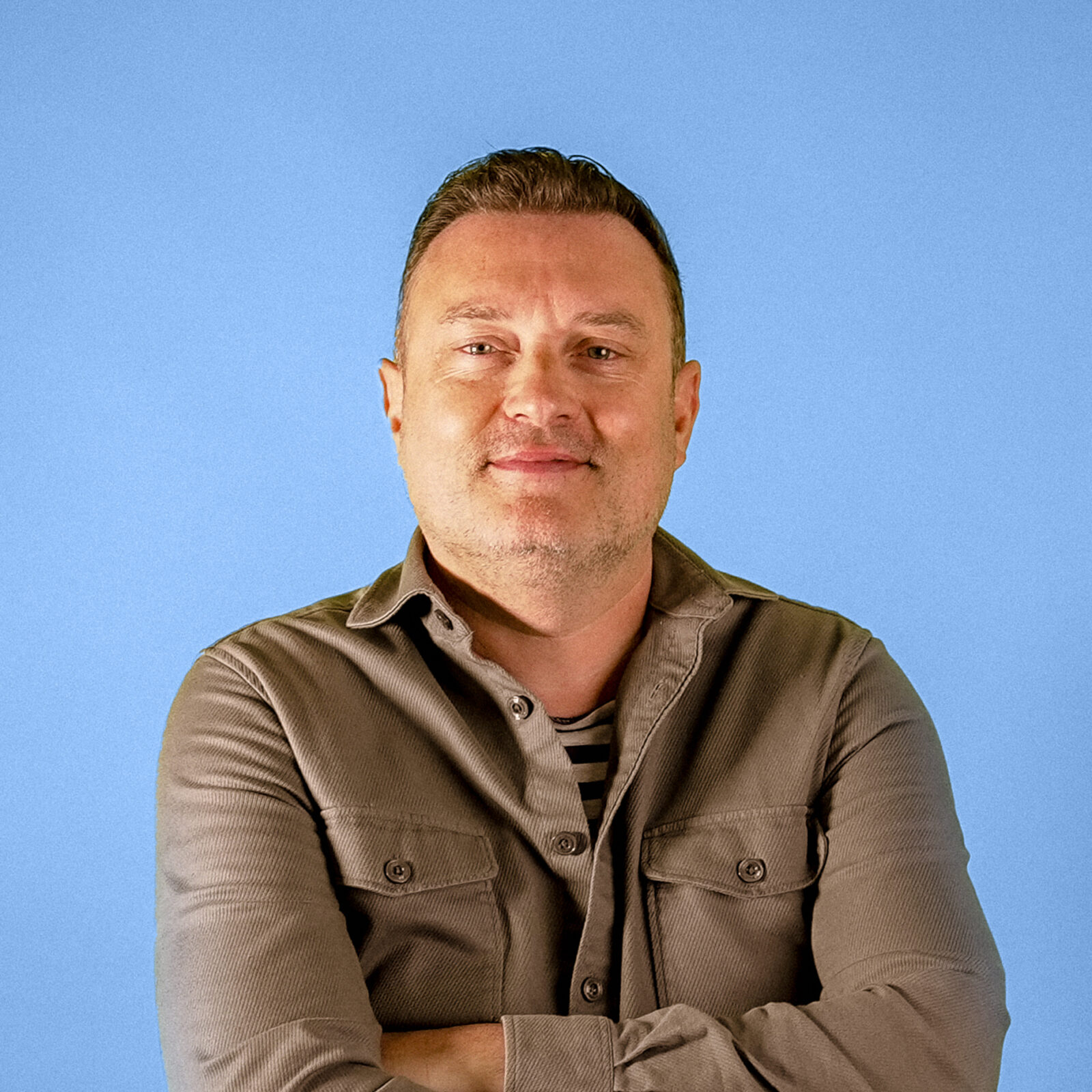 Headshot of Joe Nixon, Founder & Director, on blue background